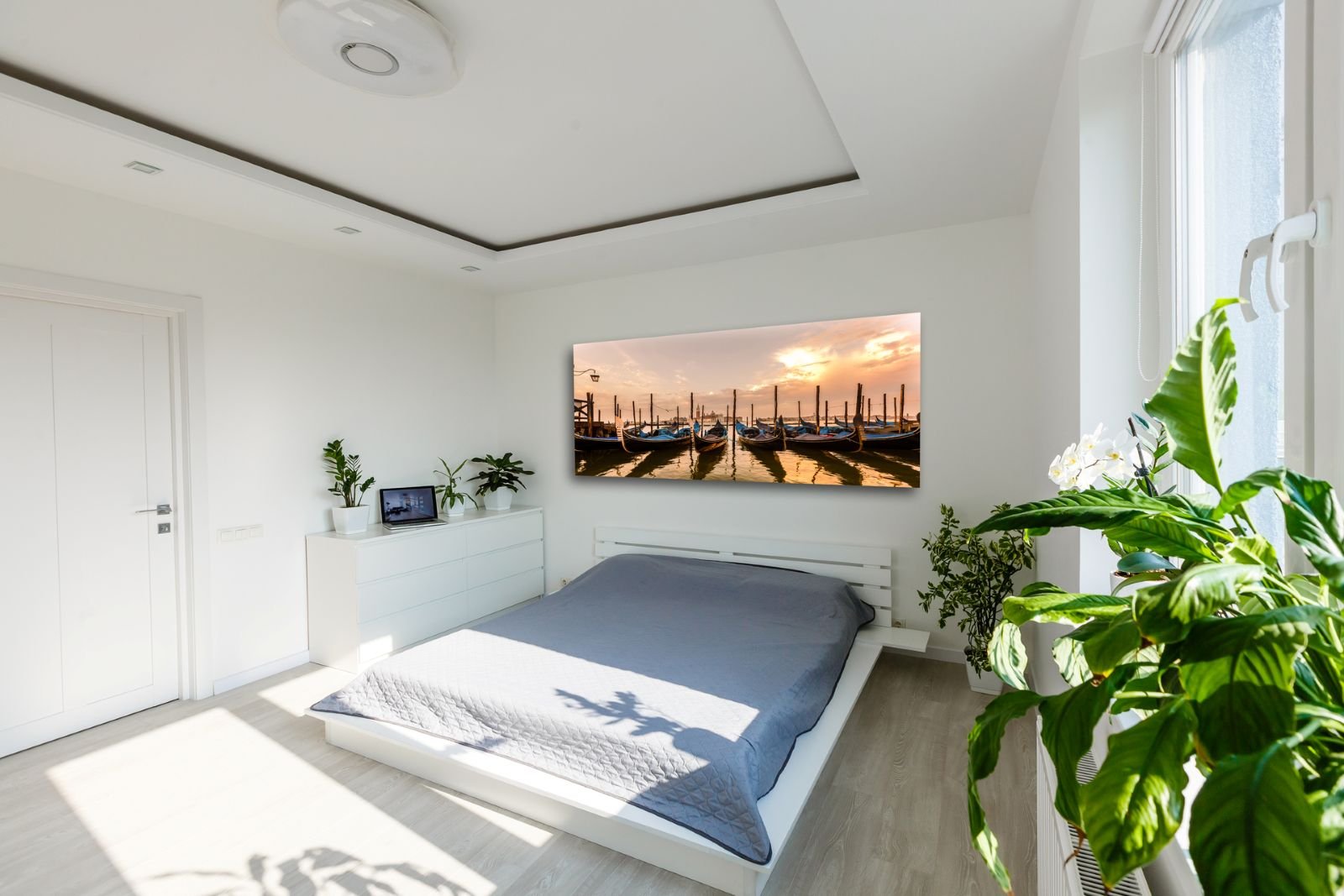 Elegant primary bedroom with upholstered bed, layered bedding and warm lighting