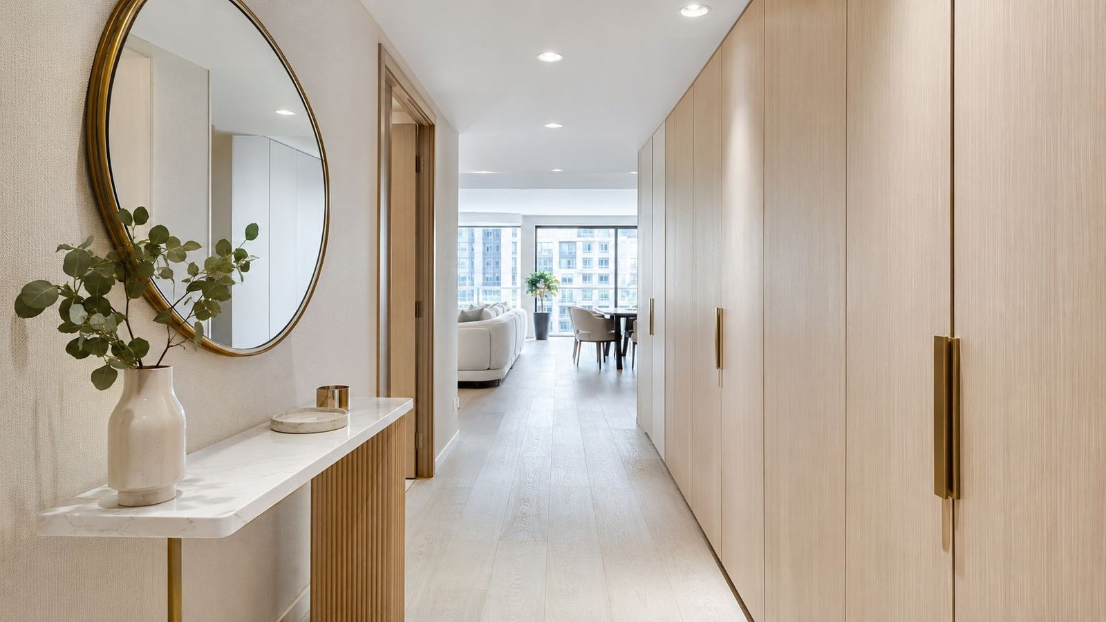 Bright condo hallway with entryway console, mirror and custom storage